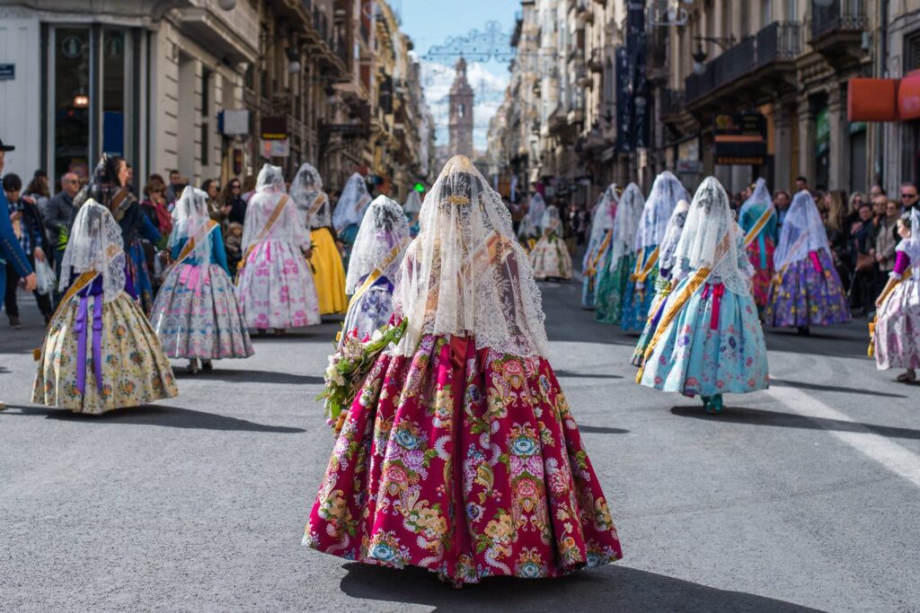 Falleras w tradycyjnych strojach idą w procesji Ofrenda de Flores, jednym z najpiękniejszych momentów marcowego święta Fallas w Walencji