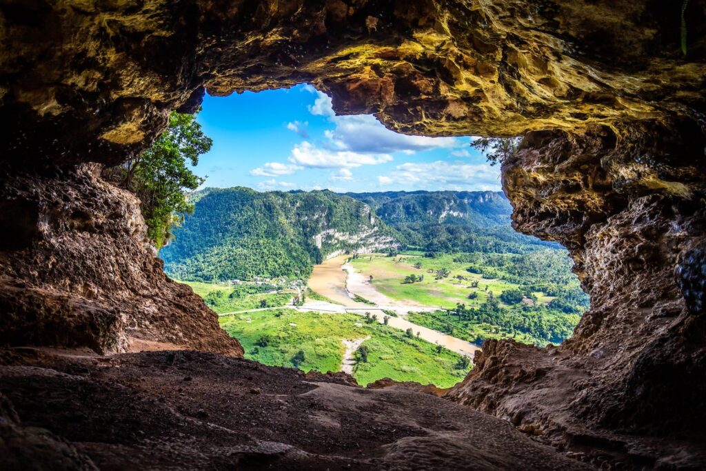 Z Jaskini Okno w Cueva Ventana rozciąga się widok na zieloną dolinę rzeki