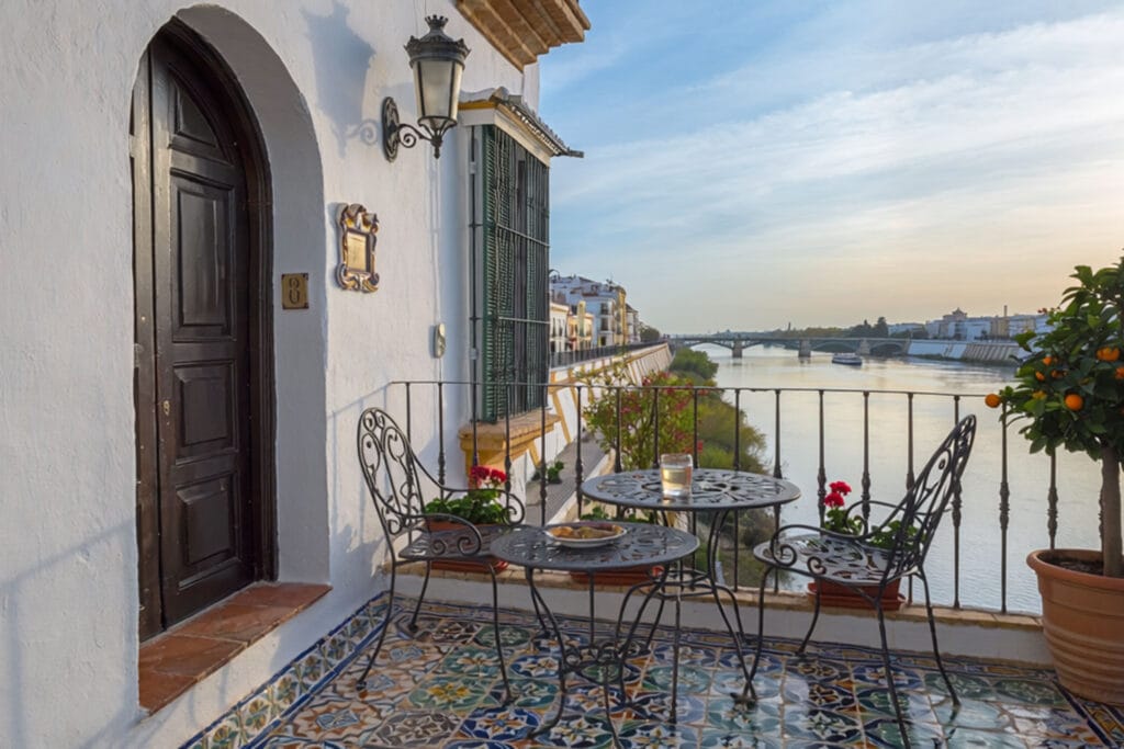 Balkon z widokiem na Gwadalkiwir w eleganckim hotelu w Sewilli. Zdjęcie wygenerowane przez AI.