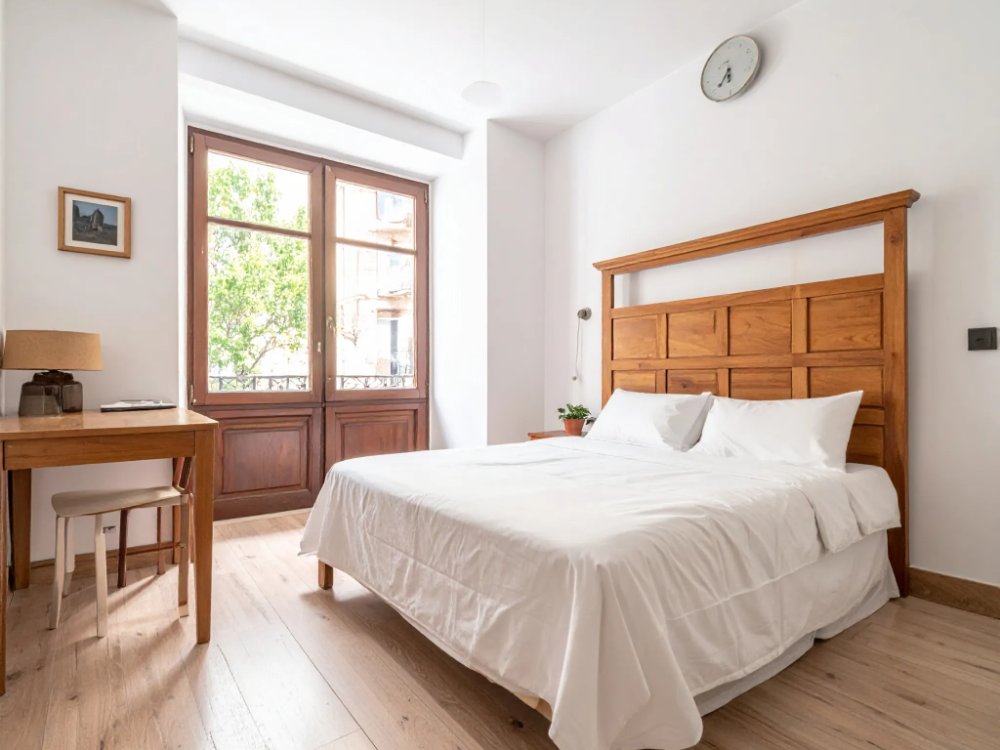 Skromny, jasny pokój w hostelu w centrum Madrytu. Zdjęcie wygenerowane przez AI.